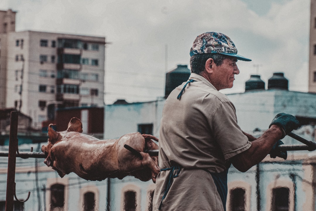 man in gray long sleeve shirt and blue and white floral cap