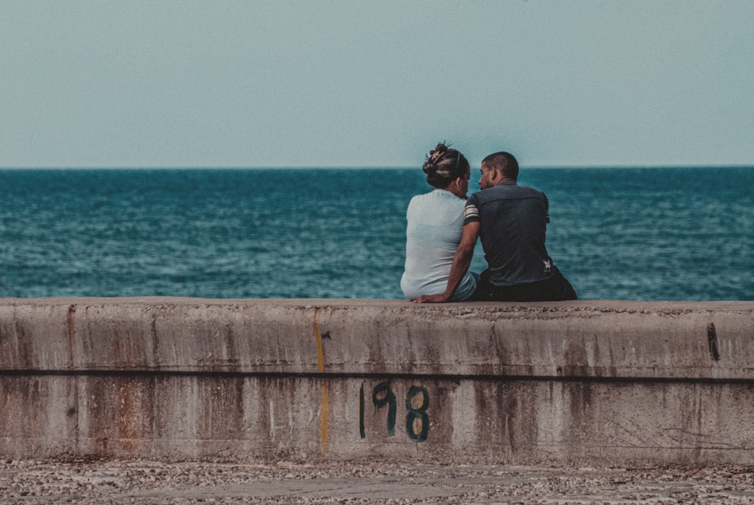 couple kissing on brown wooden dock during daytime