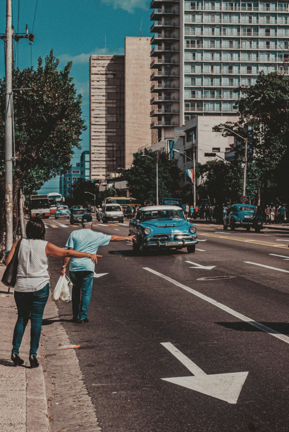 man in white dress shirt and black pants walking on pedestrian lane during daytime