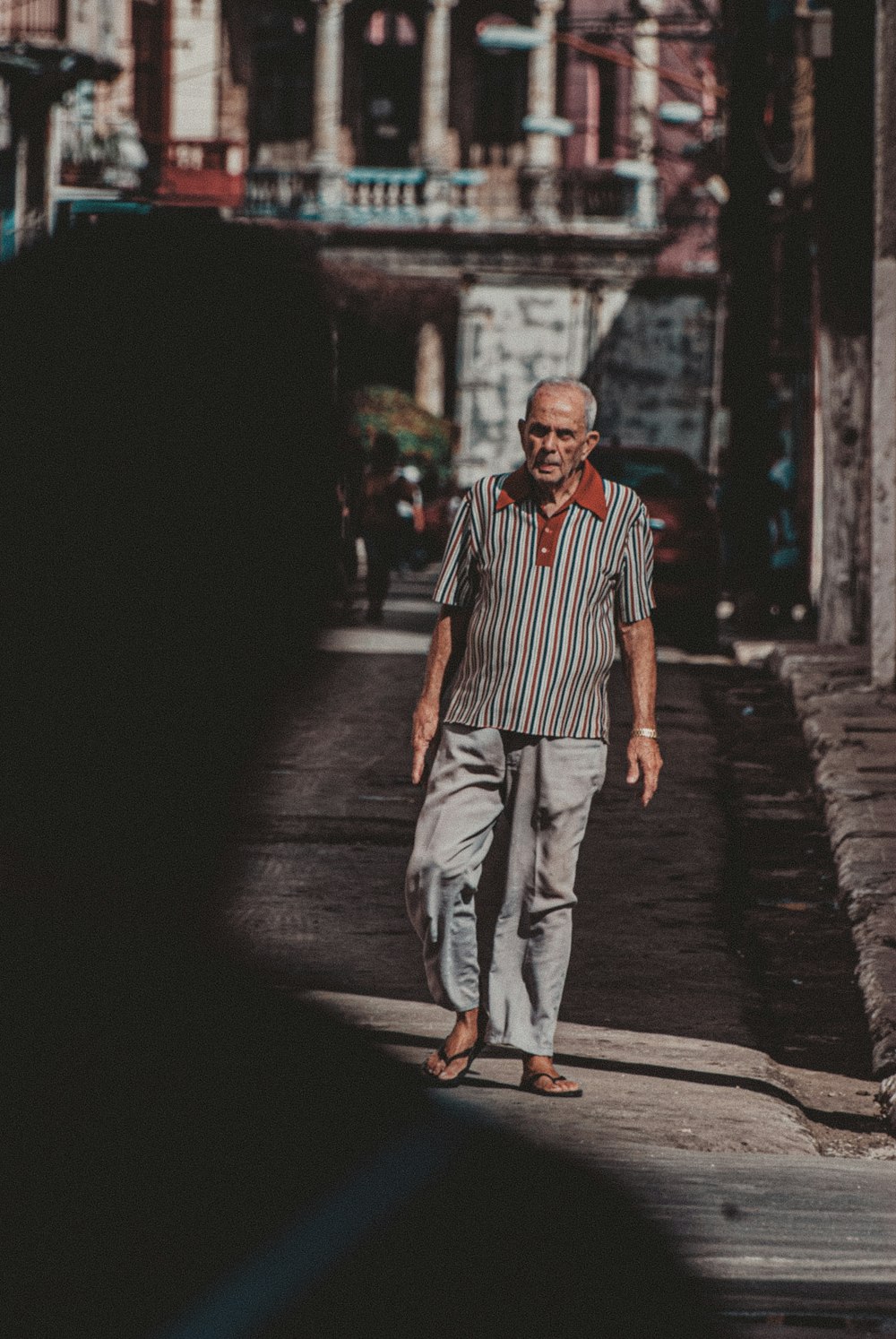 Uomo in camicia a righe bianche e rosse e pantaloni grigi in piedi sul  sentiero di cemento grigio durante foto – Grigio Immagine gratuita su  Unsplash