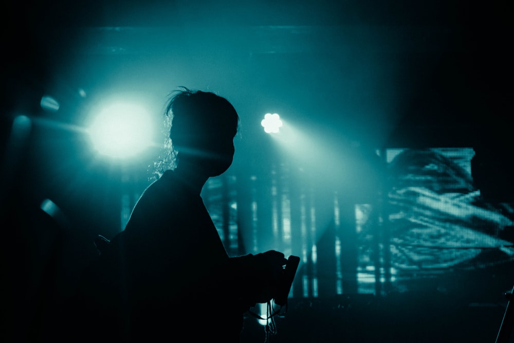 silhouette of man standing in front of light