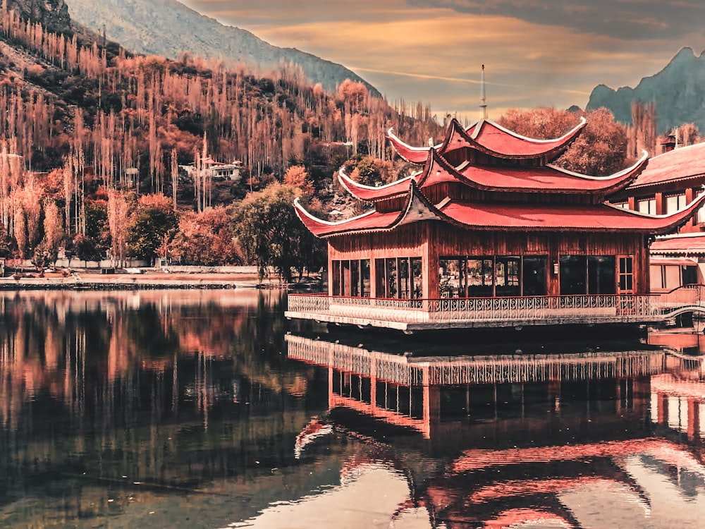 brown and red wooden house on lake