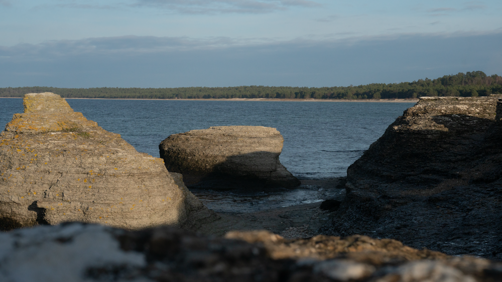 rochas marrons perto do corpo de água durante o dia