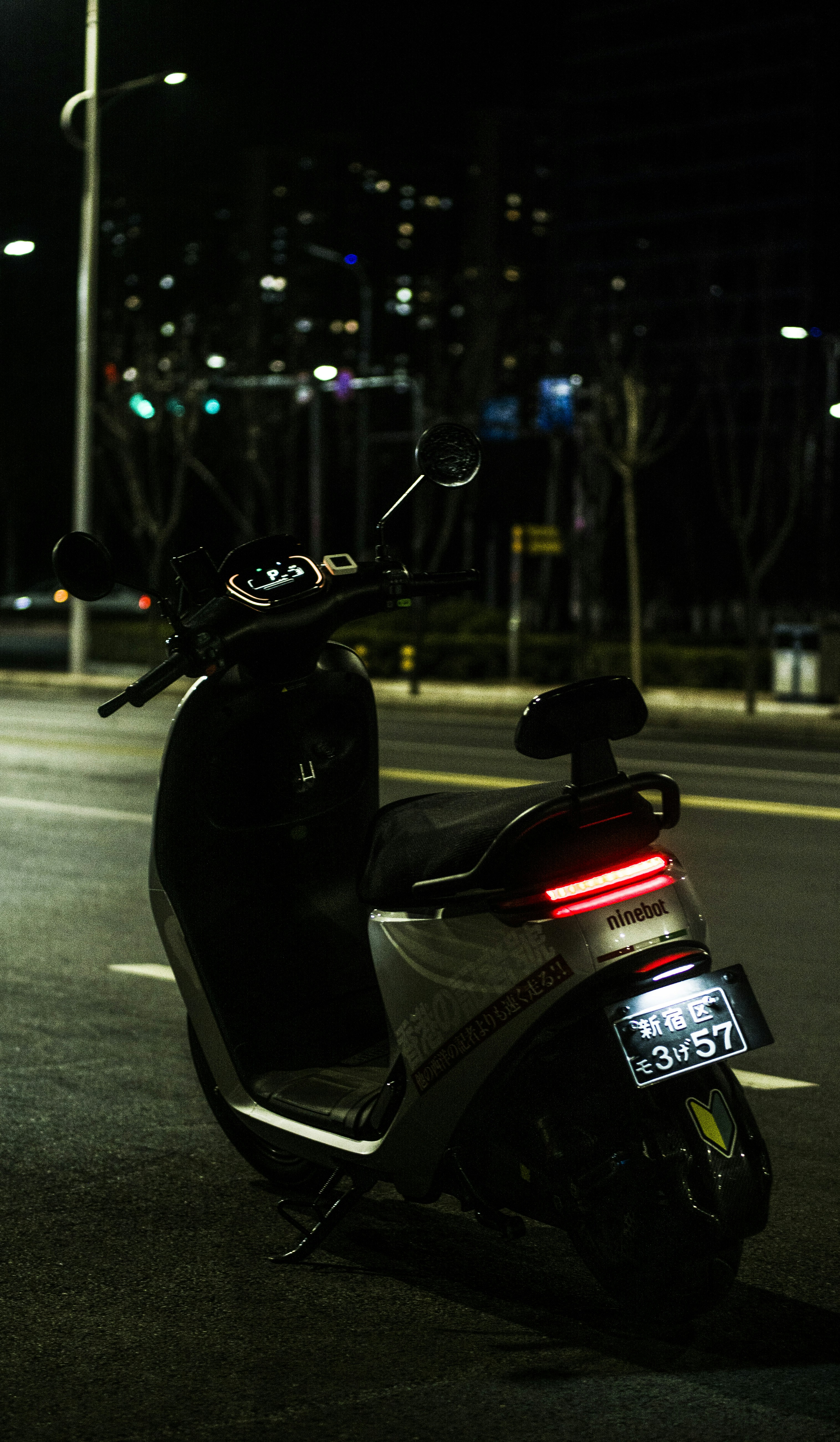 black and red motor scooter on road during night time