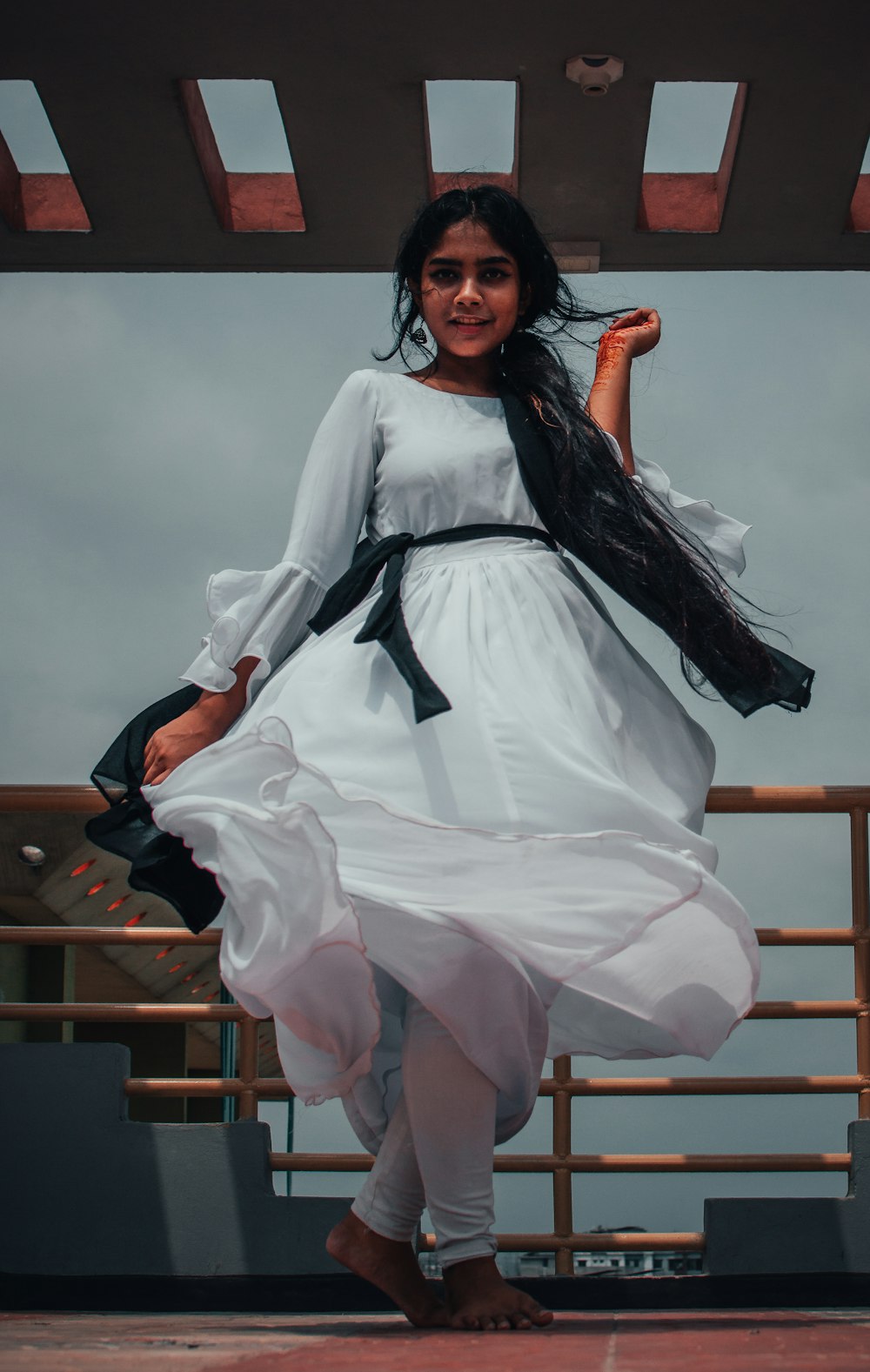 woman in white and black dress sitting on brown wooden chair