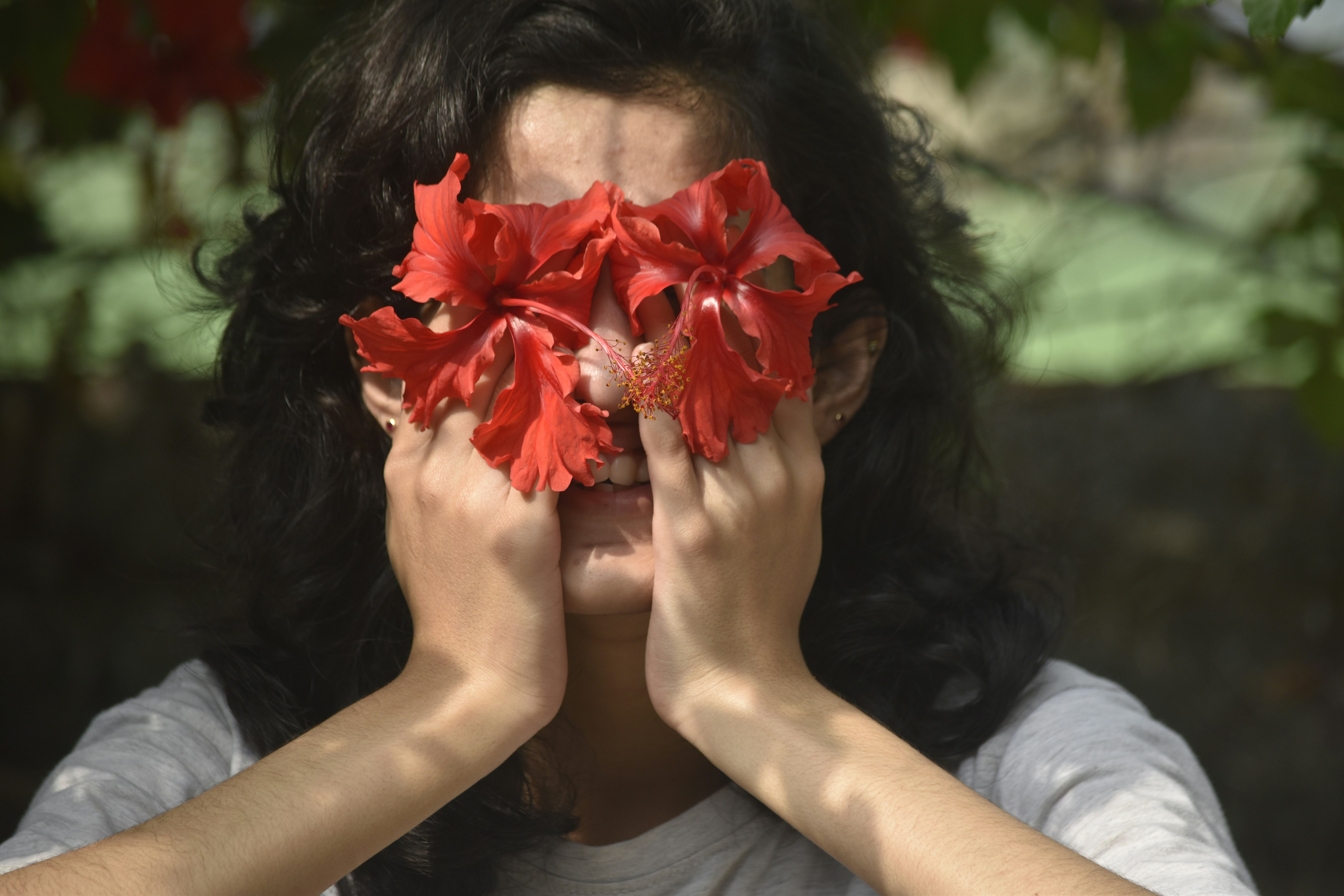 woman in white shirt holding red maple leaf