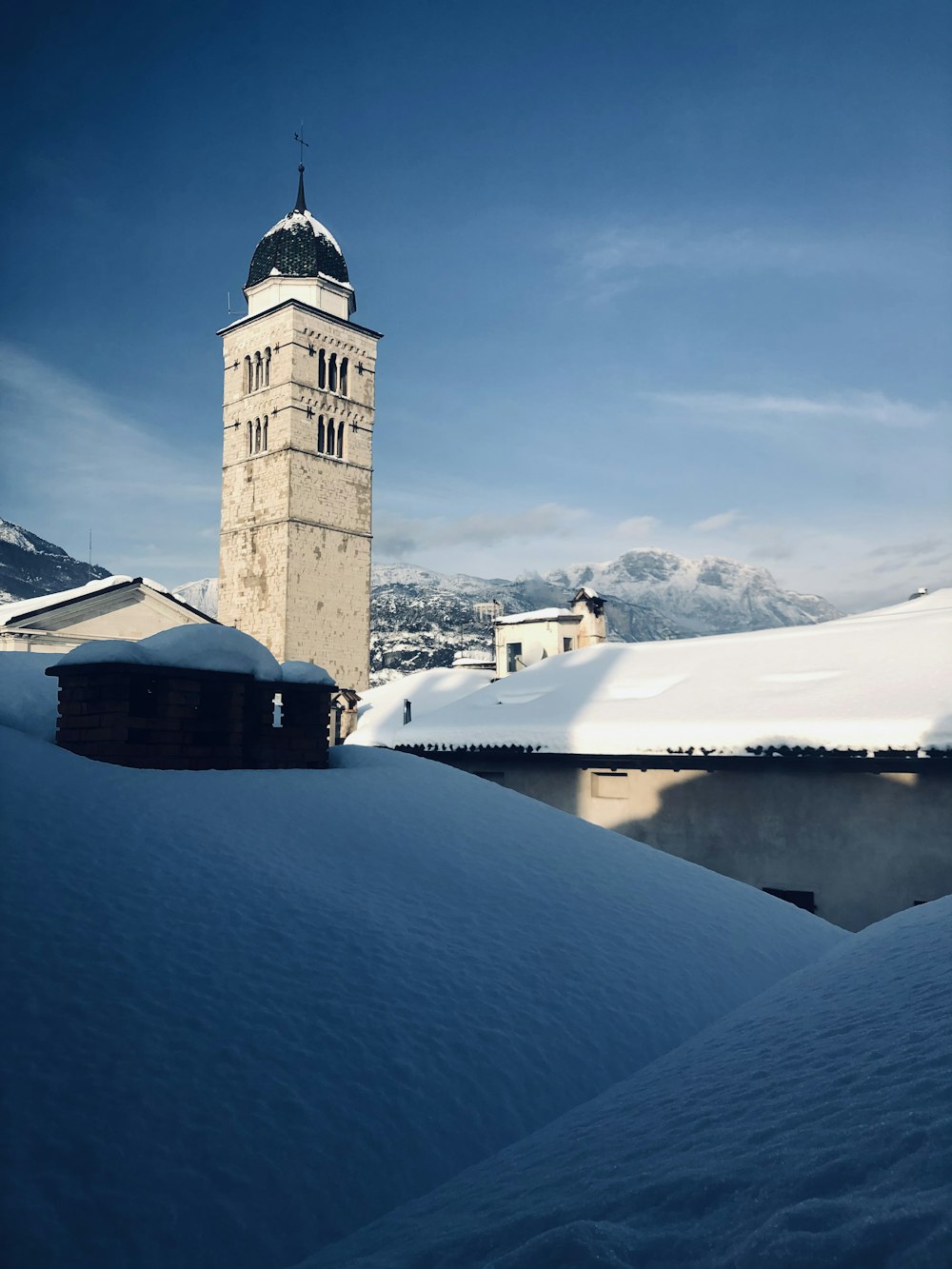 Edificio de hormigón marrón en una montaña cubierta de nieve durante el día