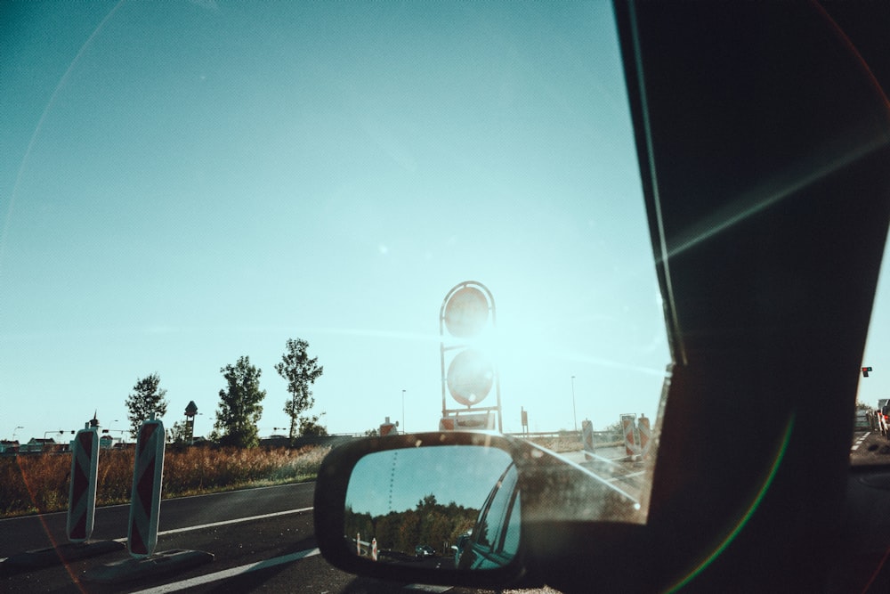 car side mirror with a view of a car on the road during night time