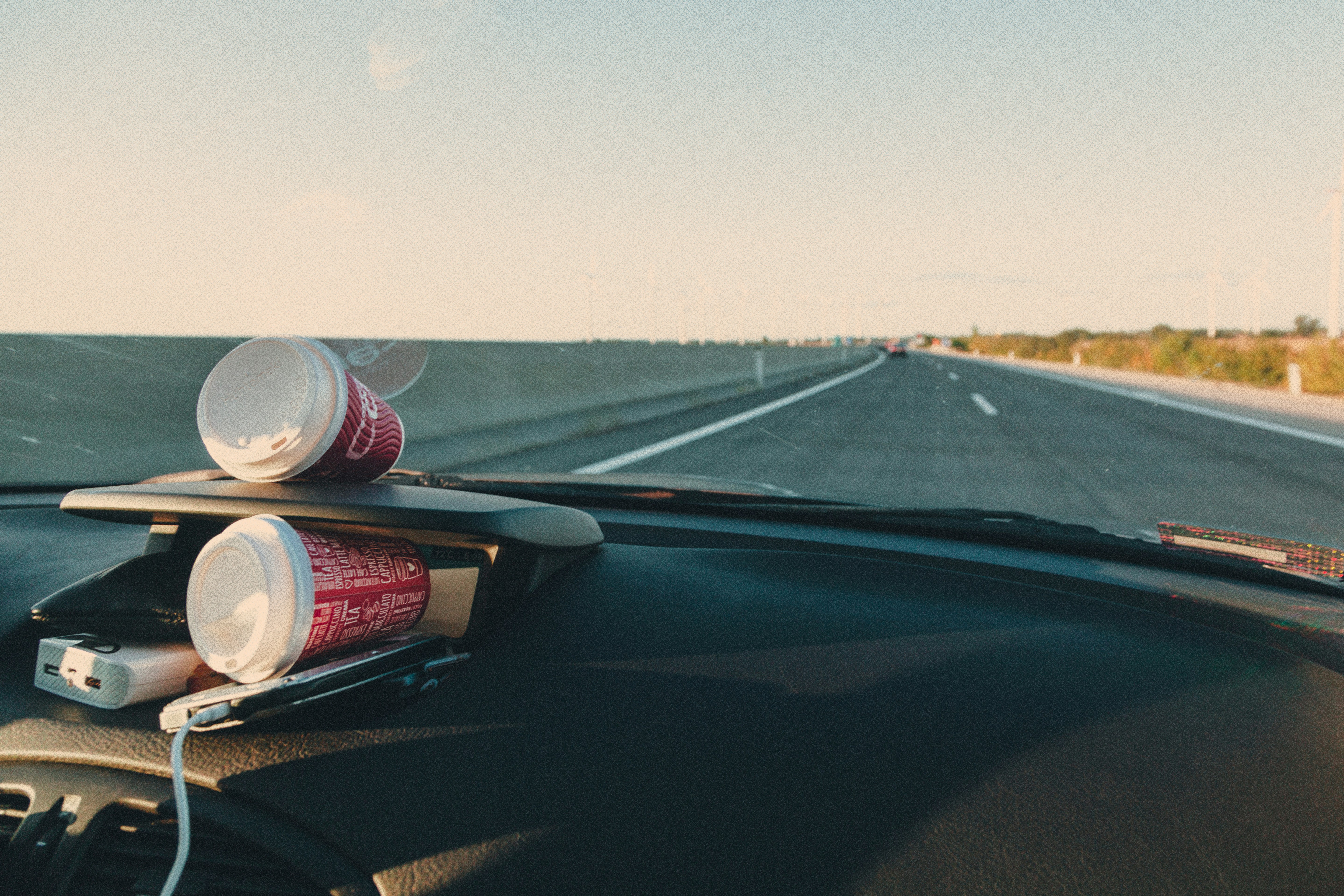 white and red labeled bottle on car dashboard, 