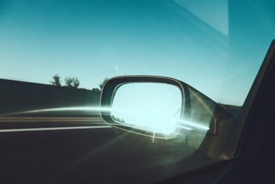 A clean and polished car windshield reflecting sunlight on a clear day.