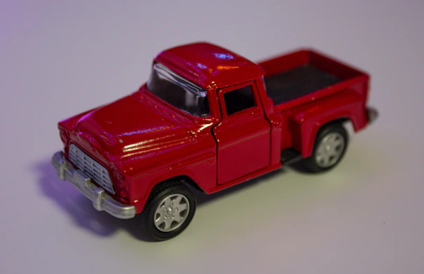 A shiny red pickup truck gleaming with polished chrome details in the showroom.