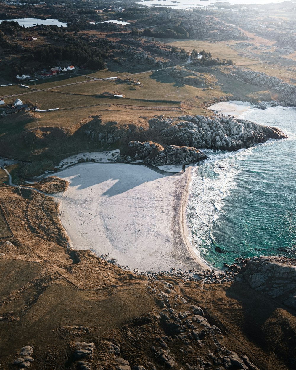 aerial view of brown land near body of water during daytime