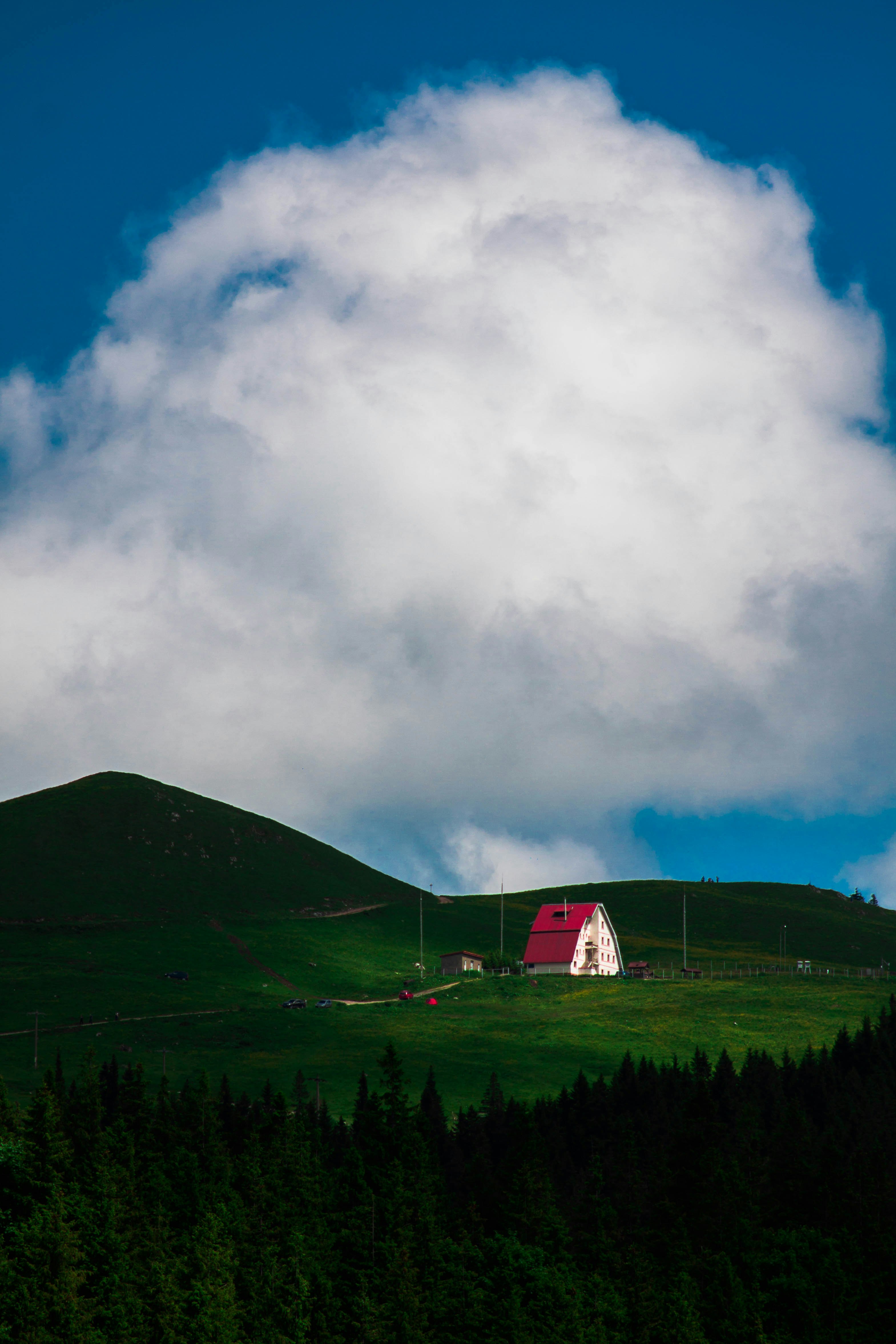 white and red house on green grass field under white clouds