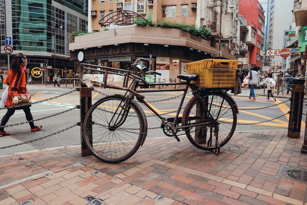 black bicycle parked on sidewalk near brown concrete building during daytime