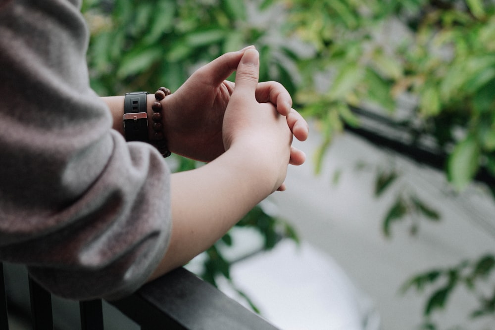 Persona in camicia grigia a maniche lunghe che tiene la mano del bambino