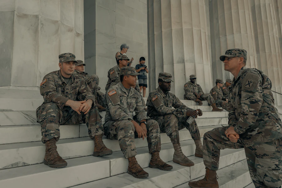 A diverse group of service members resting and talking together at a memorial