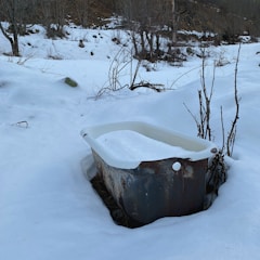 Photograph of a winter bath with snow-covered trees around.