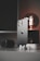 A sleek smartphone with a metallic finish stands upright on a table alongside a modern smartwatch, wireless earbuds, and a glowing antique-style bulb. The scene is set against a dark background, emphasizing the shiny surfaces and elegant technology.