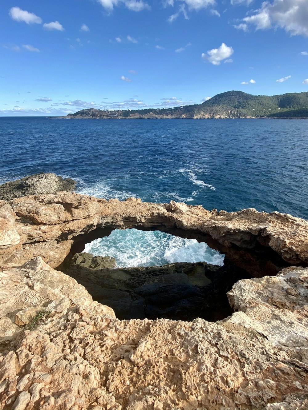 gray rock formation near blue sea under blue sky during daytime