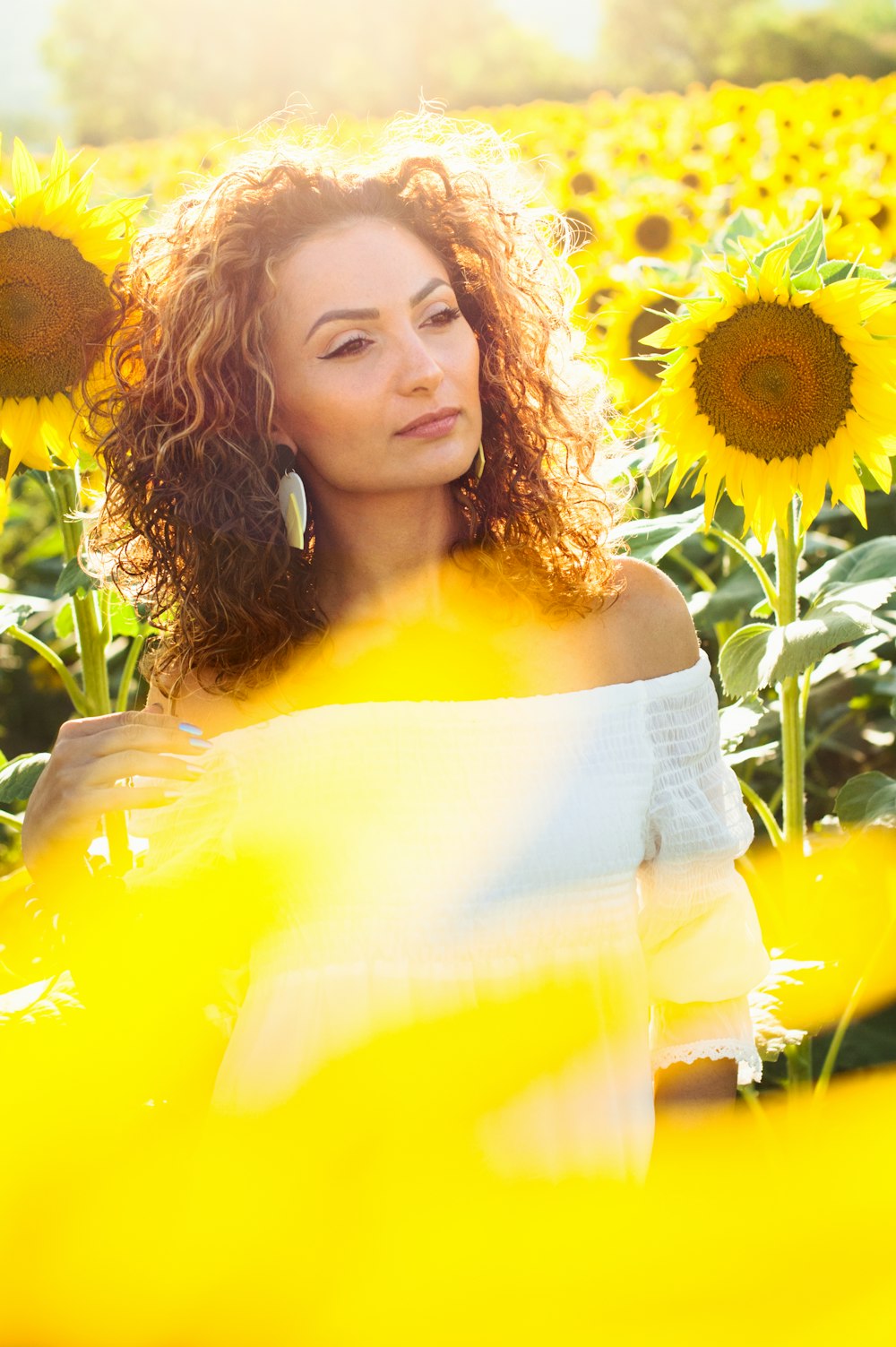woman in white tube dress standing on sunflower field during daytime