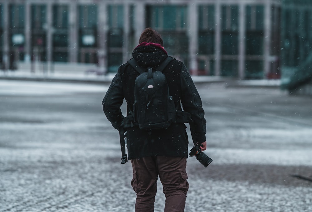 Foto de persona con chaqueta negra y jeans azules sosteniendo un paraguas  caminando por una carretera cubierta de nieve durante – Imagen gratuita  Berlina en Unsplash