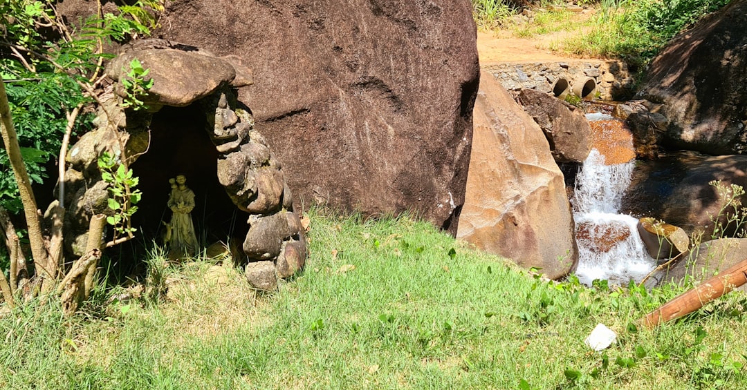 brown rock formation on green grass field during daytime