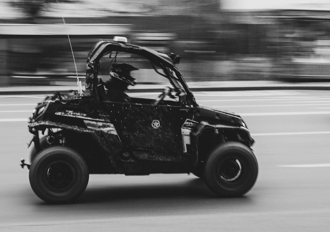 grayscale photo of black car on road