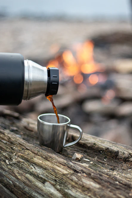 silver and black coffee mug on brown wooden table