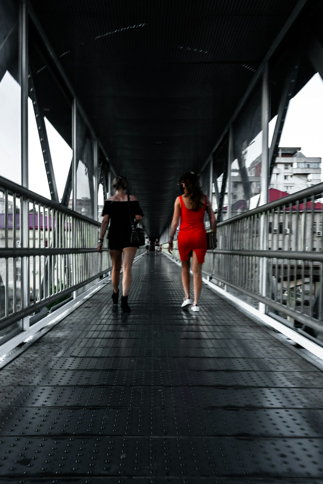 woman in red shirt walking on bridge
