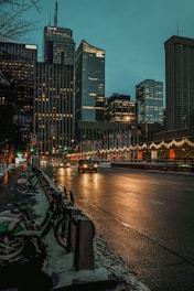 cars parked on parking lot near high rise buildings during night time