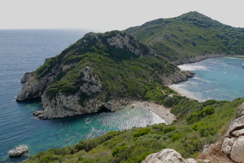 green mountain beside body of water during daytime