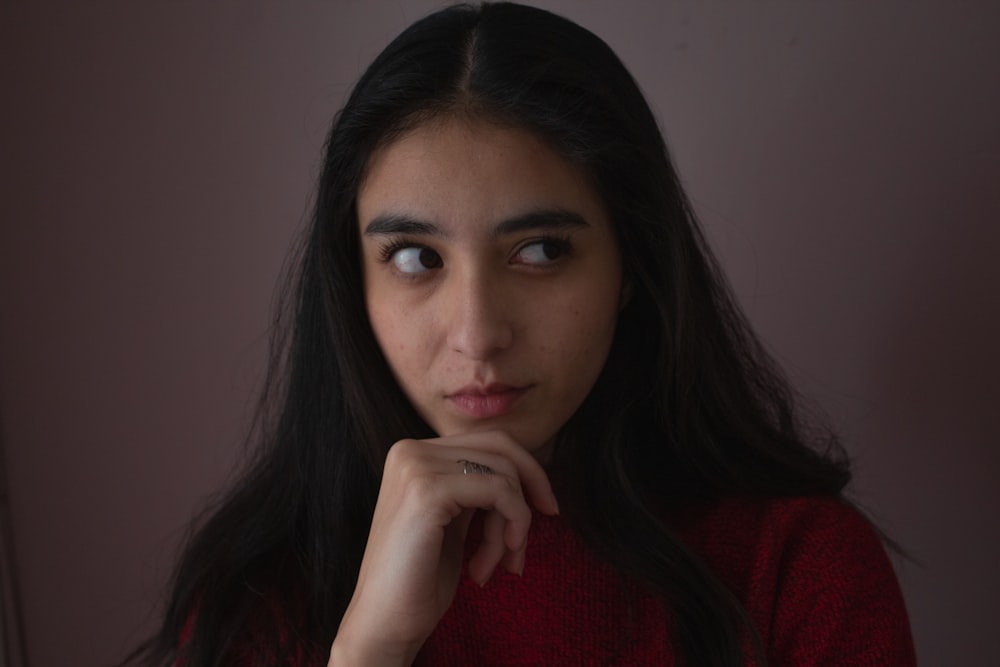 a woman in a red sweater looking at the camera