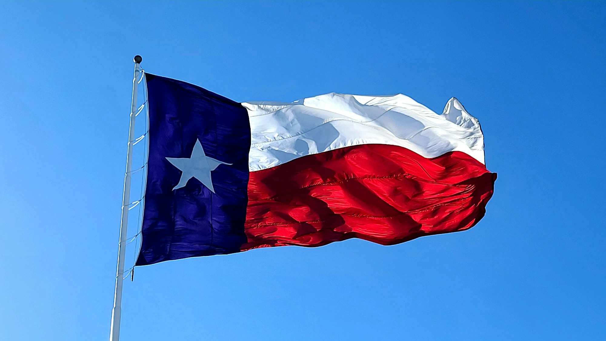 The Texas flag on a clear, windy day