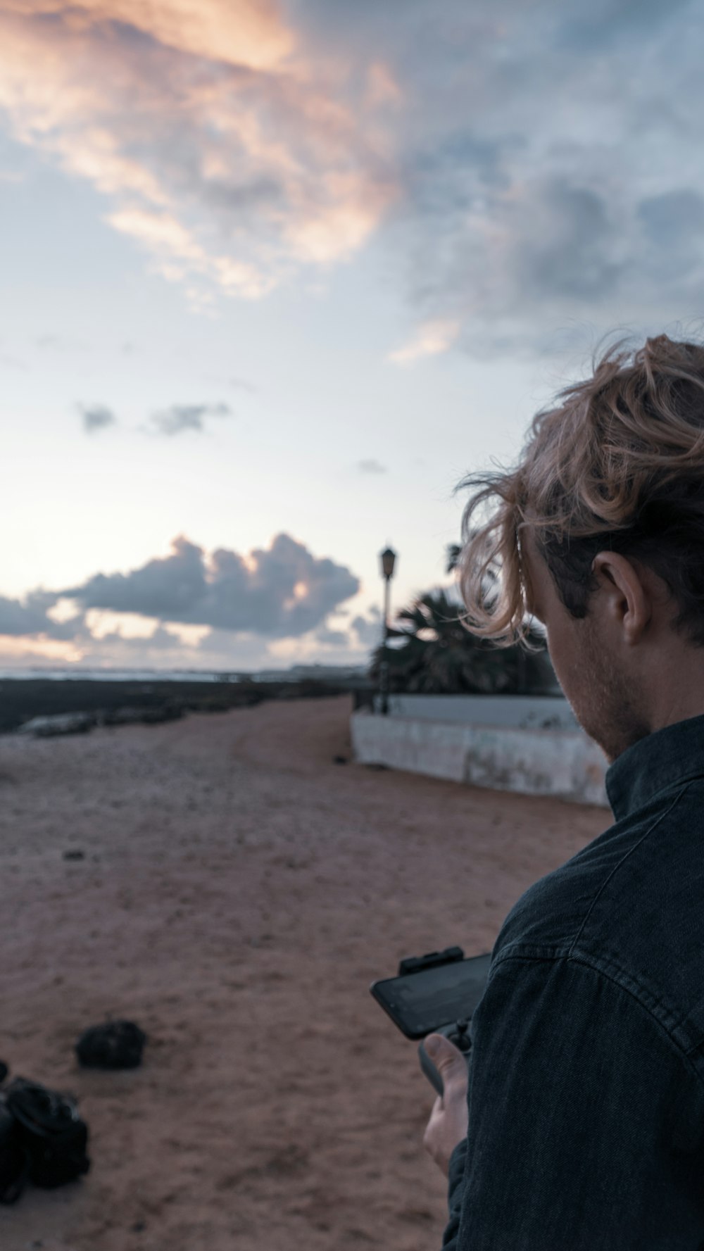 homme en veste noire portant des lunettes de soleil regardant la mer pendant la journée