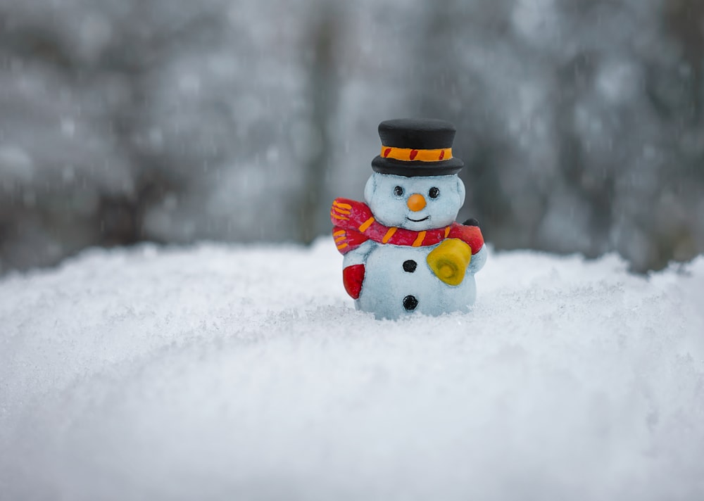 boneco de neve no lenço vermelho e estatueta de cerâmica do chapéu branco