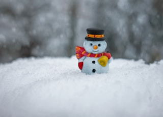 snowman in red scarf and white hat ceramic figurine