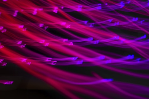 Close-up of hand-drawn typography glowing with electric blue and burnt orange against a glitchy VHS-style backdrop.