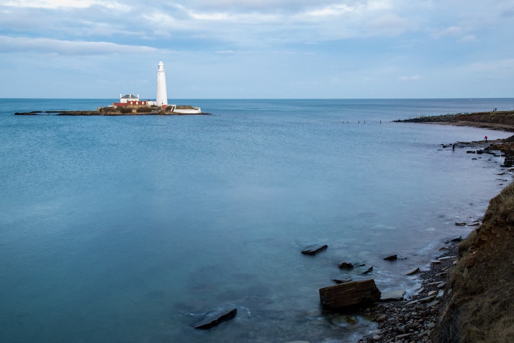 white and brown lighthouse on the sea shore during daytime