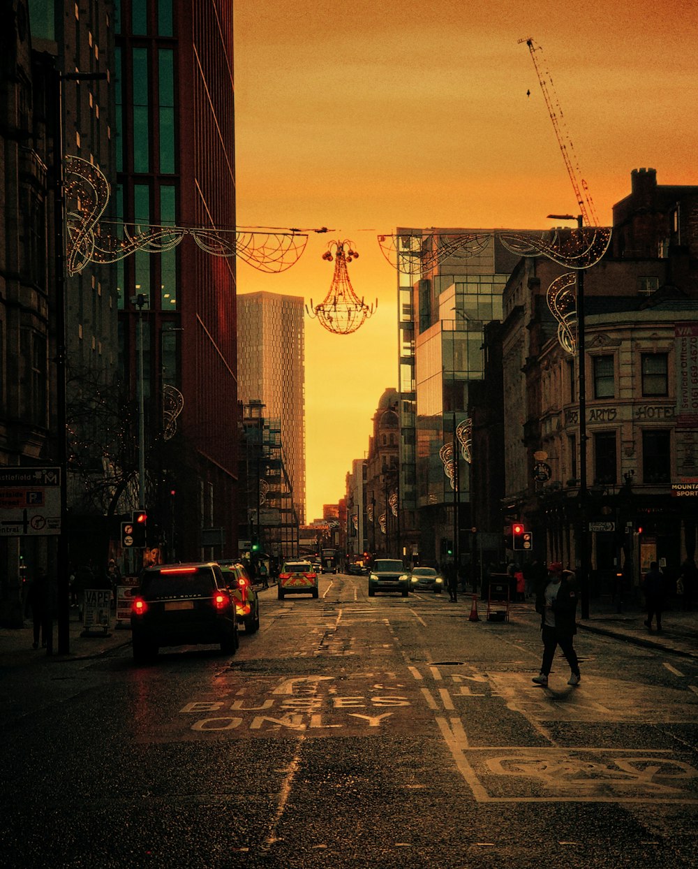 cars on road near buildings during sunset