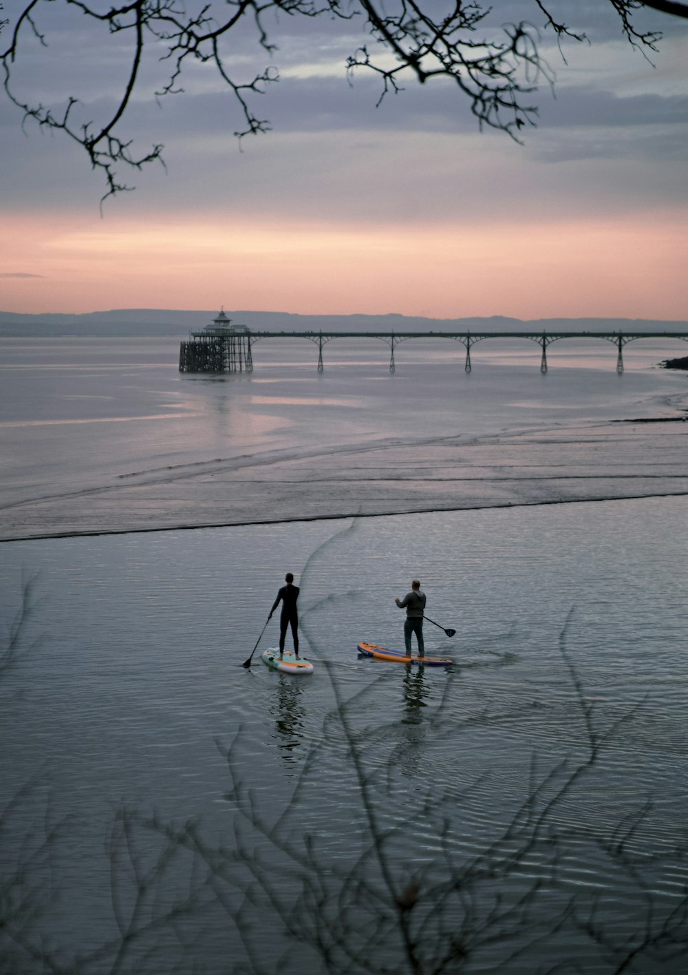 2 person riding on boat on sea during sunset