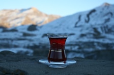 Guest enjoying a warm cup of tea by the window with snow-capped mountains in the background.