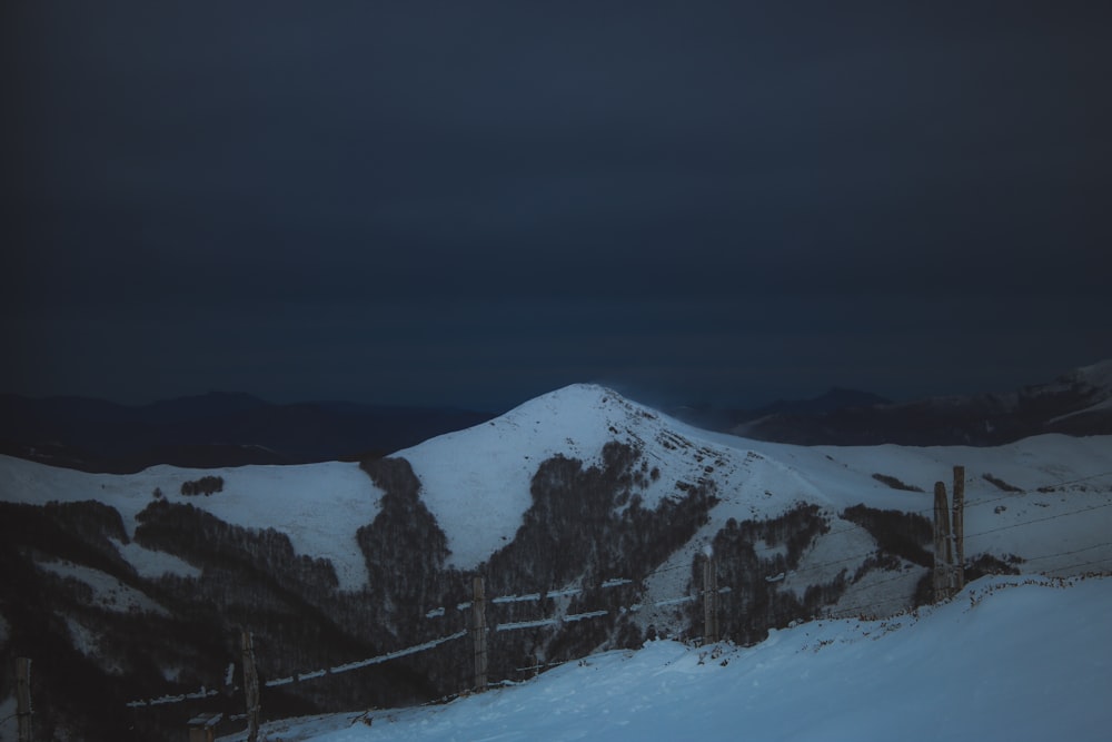 snow covered mountain under gray sky