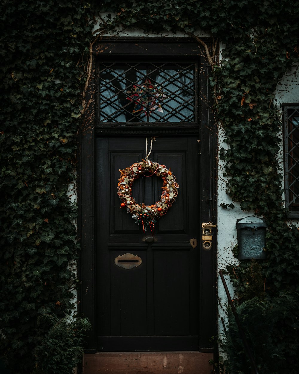 brown wreath on black wooden door