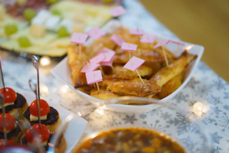 Close-up of hands arranging colorful fiesta-themed appetizers on a rustic wooden table.