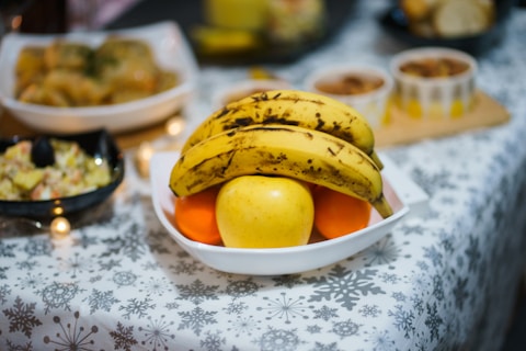 yellow banana fruit on white ceramic bowl