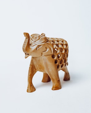 gold elephant figurine on white surface