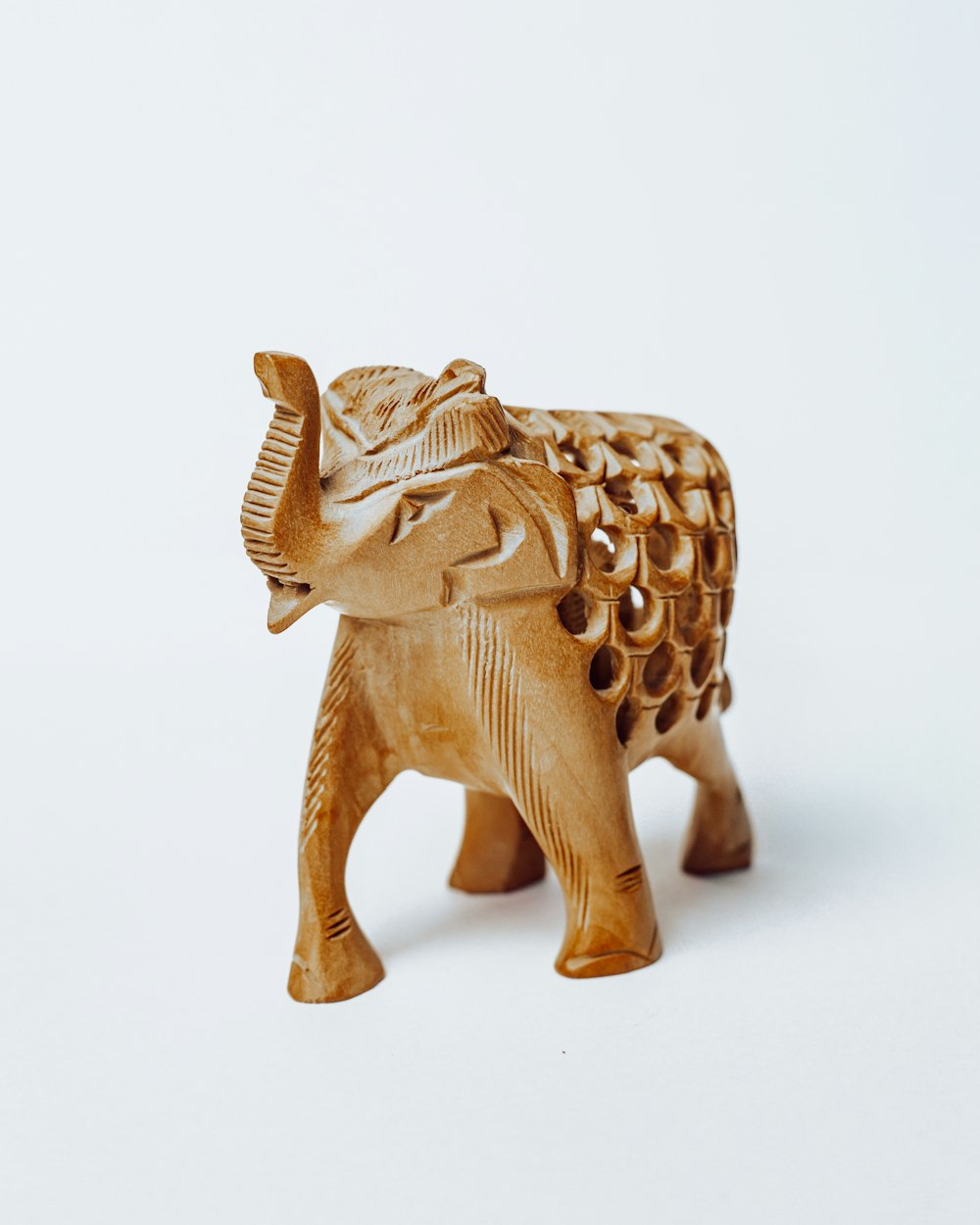 Figura de elefante de oro sobre superficie blanca