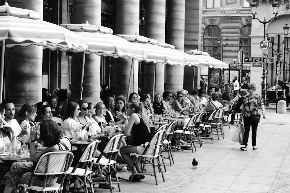 grayscale photo of people sitting on chairs