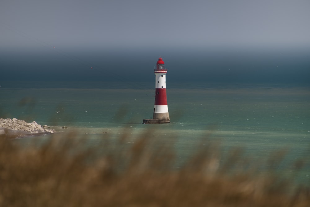 昼間のビーチの白と赤の灯台