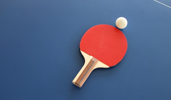 red and brown wooden table tennis racket